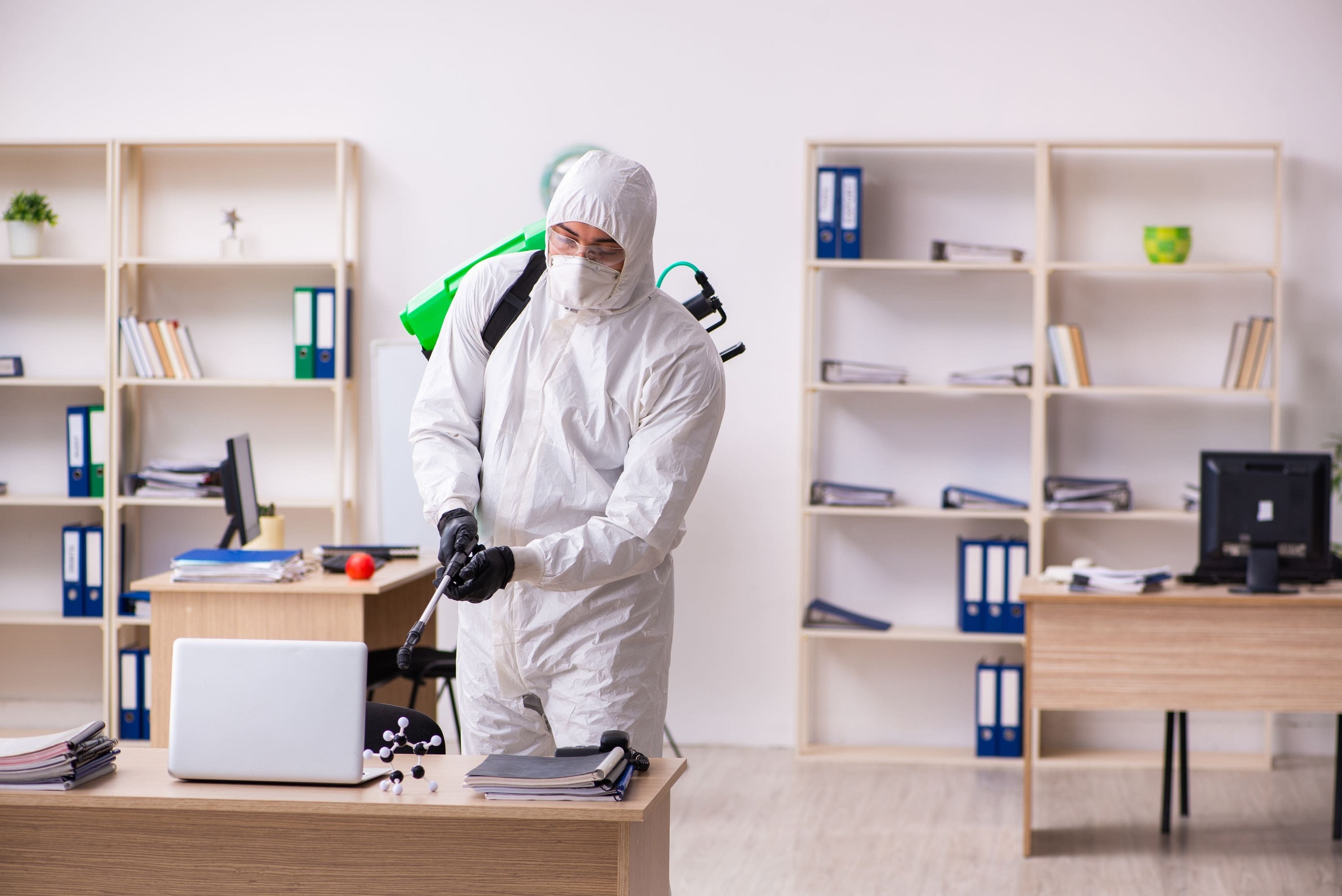 Contractor Disinfecting The Office